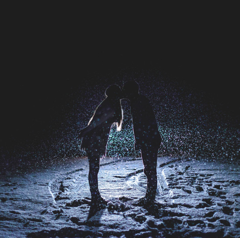 Küssendes Paar im Schnee in der Nacht